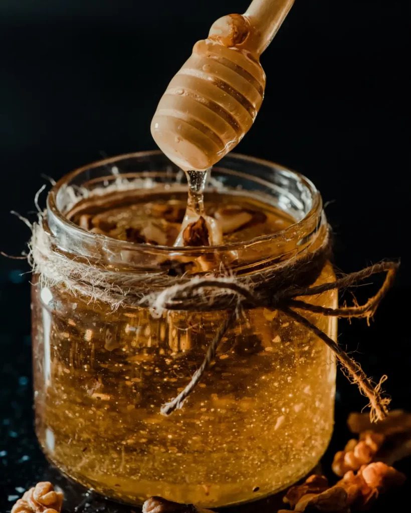 vertical-shot-of-honey-in-a-glass-jar-with-walnuts-2025-02-06-05-36-43-utc
